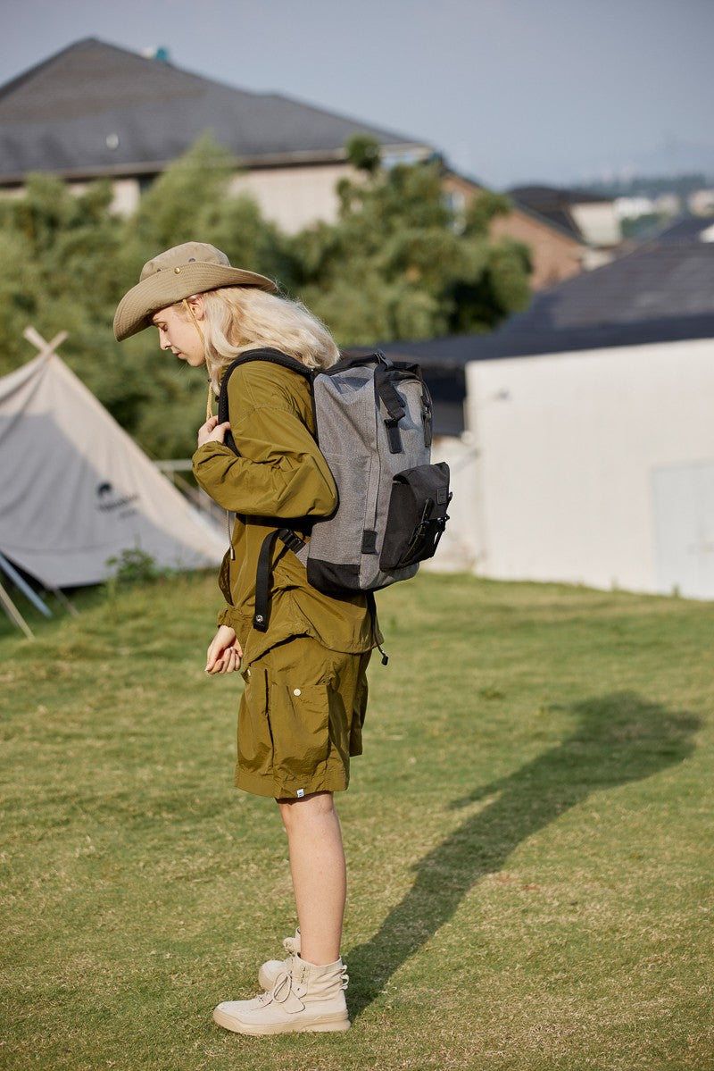 Person wearing a gray Himawari waterproof canvas backpack outdoors, showcasing its versatility for travel and daily use.