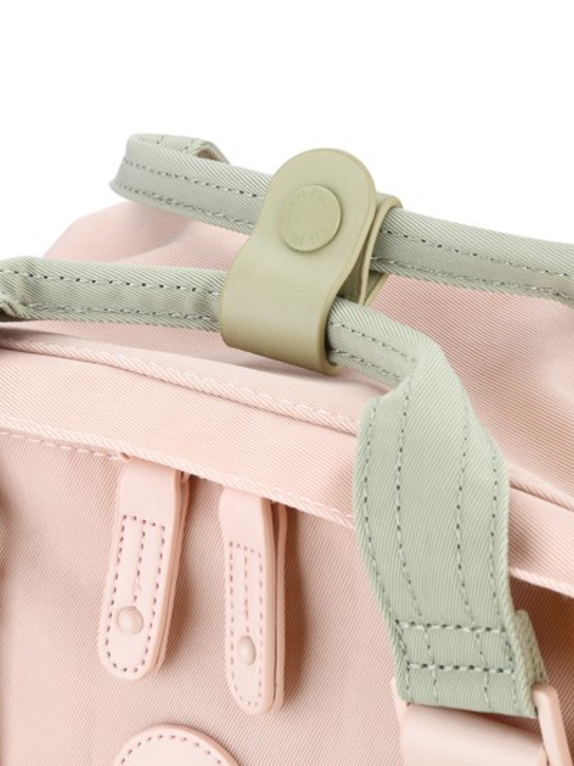 Close-up of the Himawari backpack's top snap closure and mint green straps, highlighting its secure and functional design.