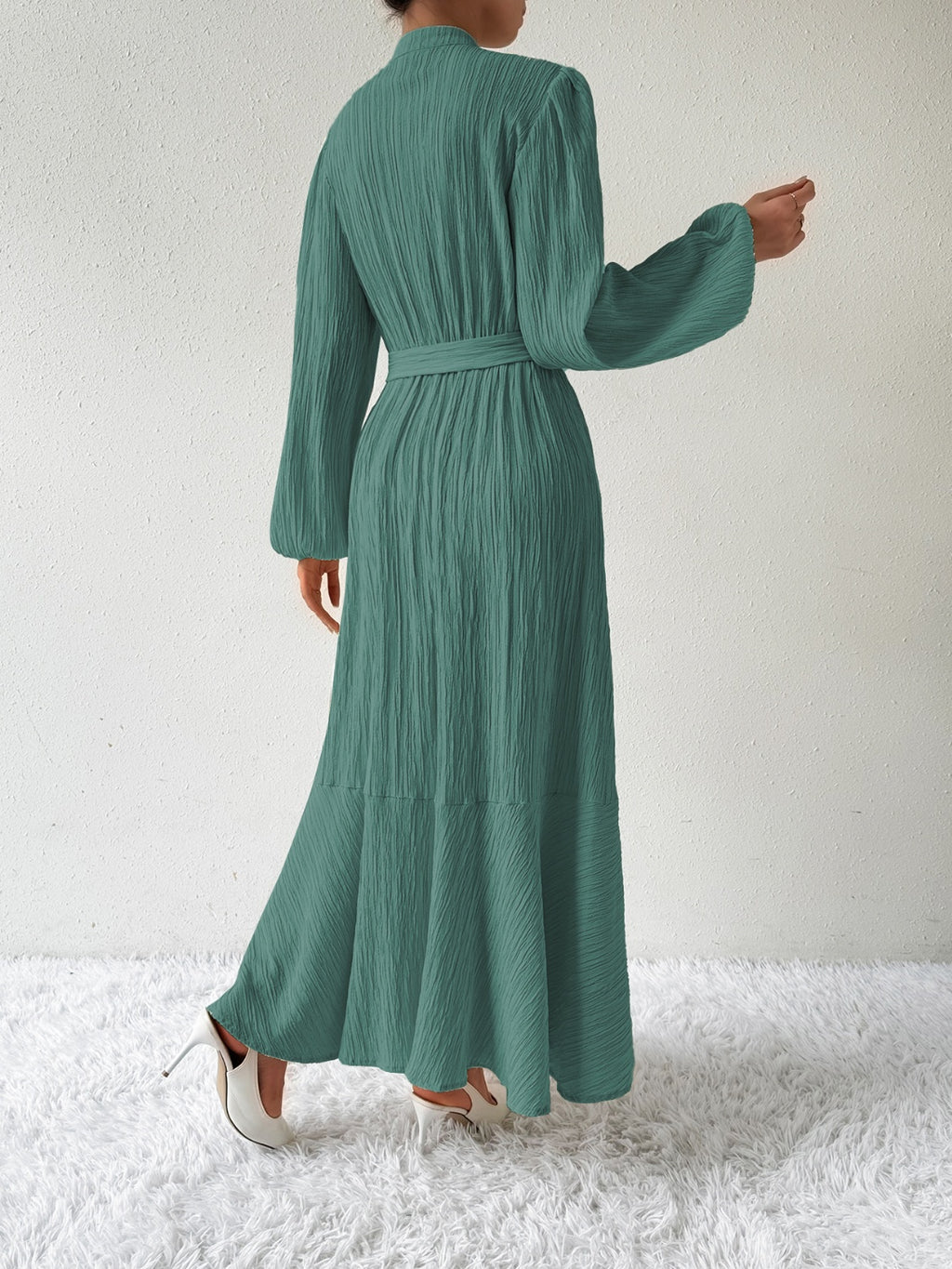 Back view of the Honey Tie Waist Long Sleeve Dress in green. Features a belted waist, textured fabric, and a flowing maxi length design.