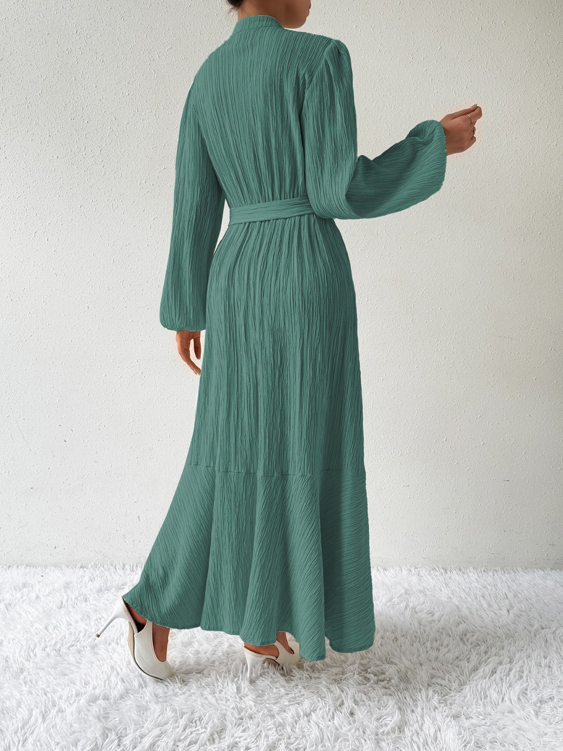 Back view of the Honey Tie Waist Long Sleeve Dress in green. Features a belted waist, textured fabric, and a flowing maxi length design.